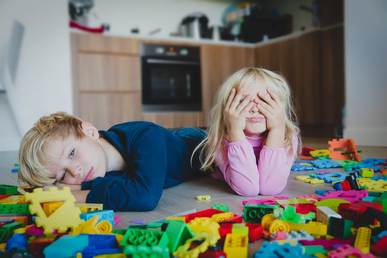 Two bored children surrounded by their old toys before getting Wuffy.